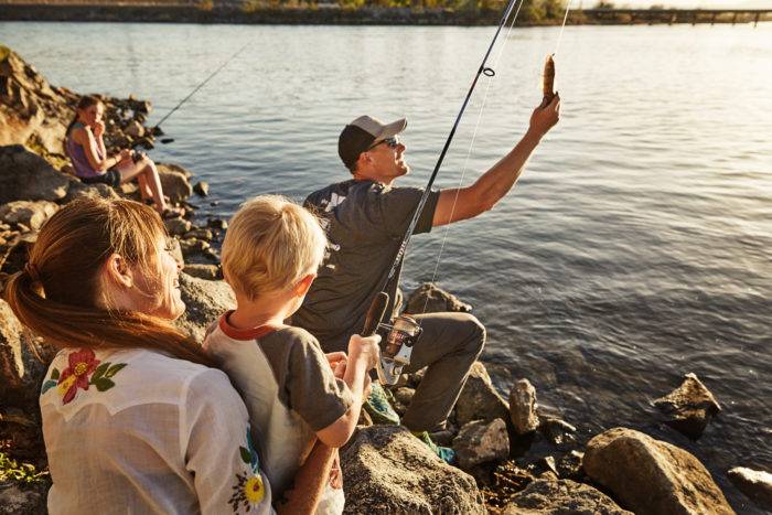 A man holding a fish on the end of a line.