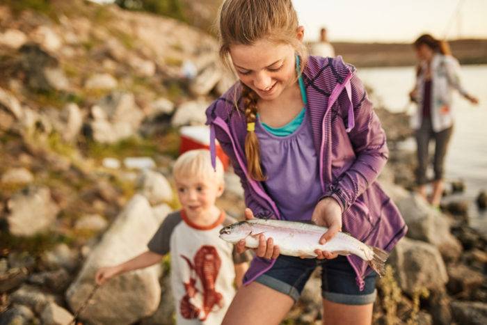 A girl holding a trout.