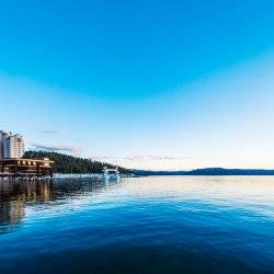 A picture of a lake with a resort on the nearby shore.