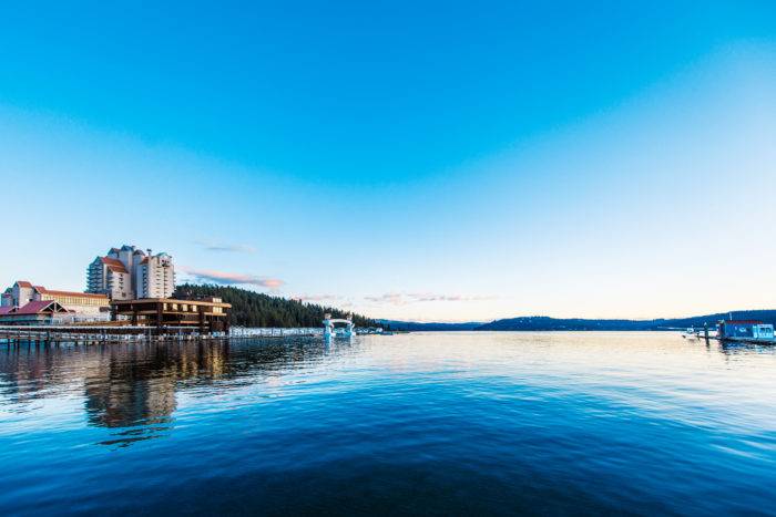 A picture of a lake with a resort on the nearby shore.