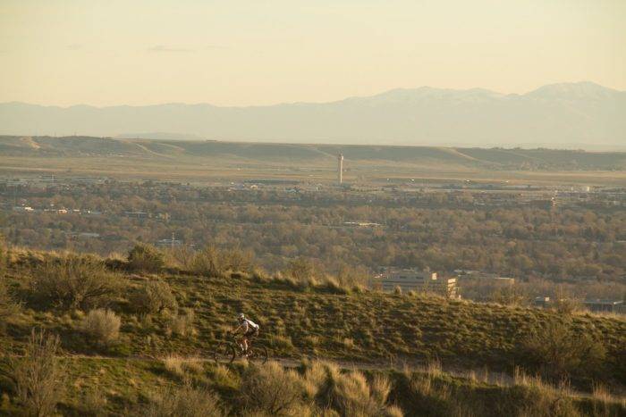 Mountain biker riding the foothills with Boise in background.