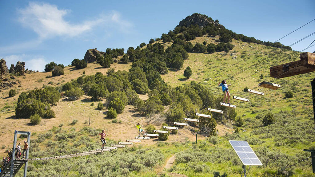 People cross a bridge at an obstacle course at Lava Zipline Adventures.