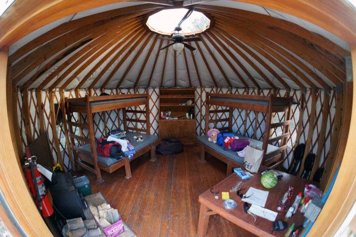 Interior of yurt with camping supplies.