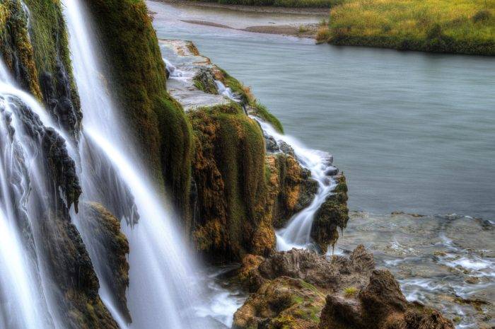 waterfall along the edge of a river.