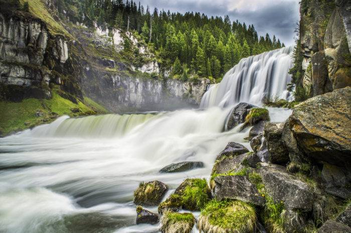 waterfall crashing into a river.