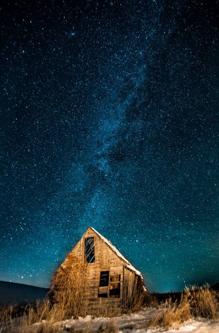 starry night behind an old wooden building.