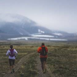 2 runners near a foggy mountain