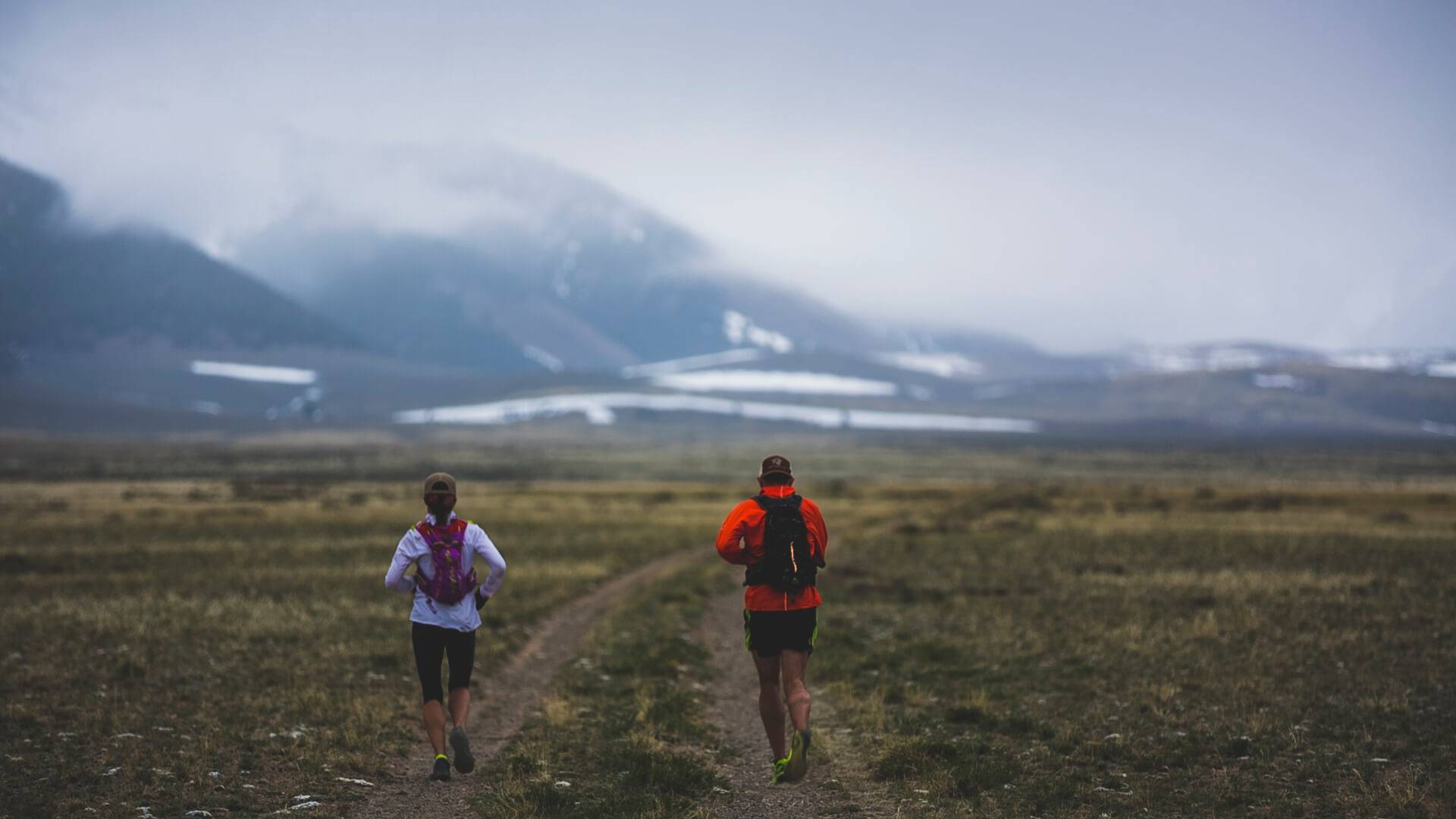 2 runners near a foggy mountain