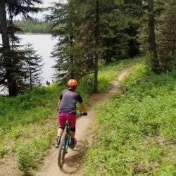 cyclist riding past a lake.