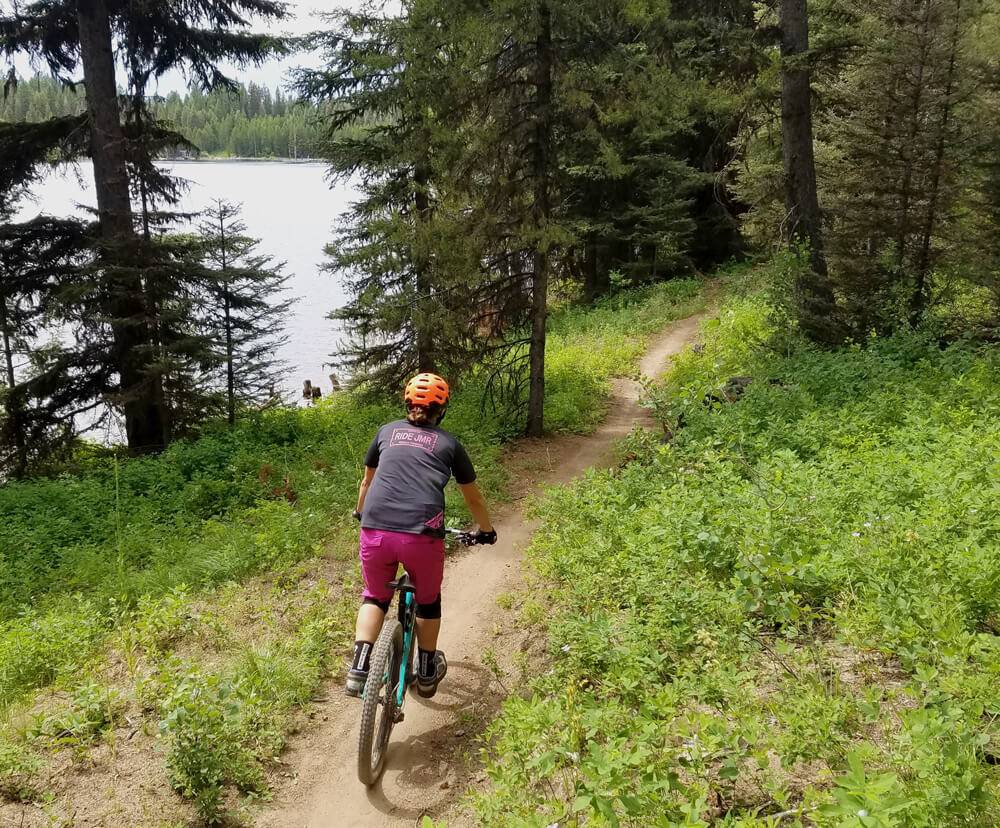 cyclist riding past a lake.