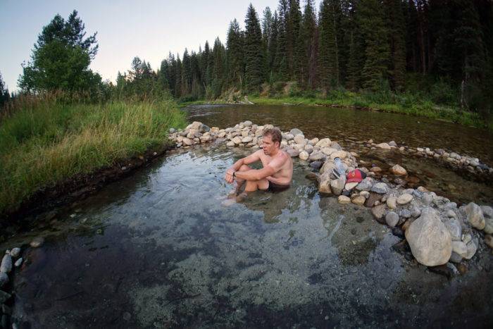 man sitting in natural hot pool