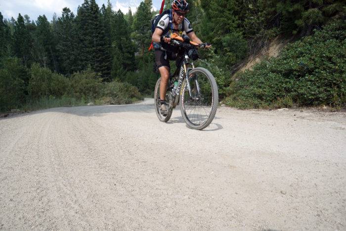 cyclist pedaling up a gravel road