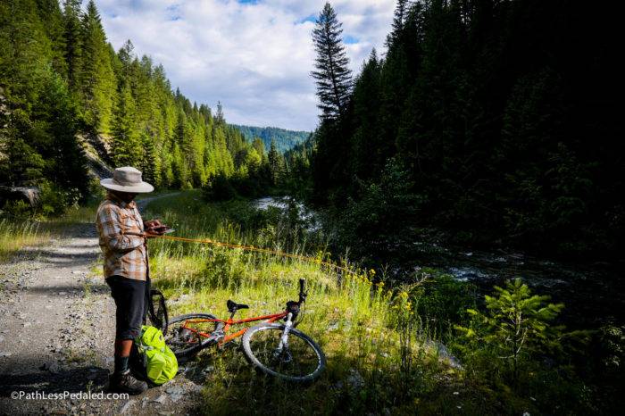 cyclist getting his fly rod ready along the river