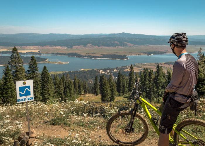 Man on mountain bike looks over lake