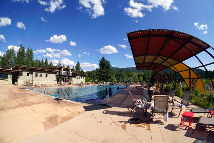 wide shot of hot pool surrounded by pine trees