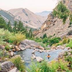 woman sitting in mountain hot pool