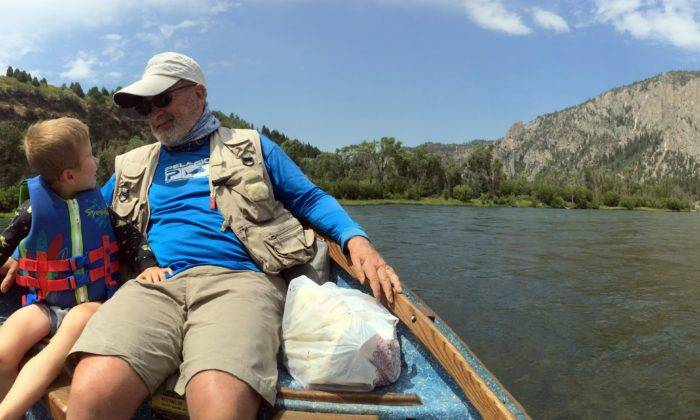 grandpa and grandson on drift boat in the river