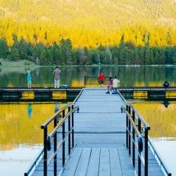 People standing at the end of a dock, fishing in the Horsethief Reservoir.