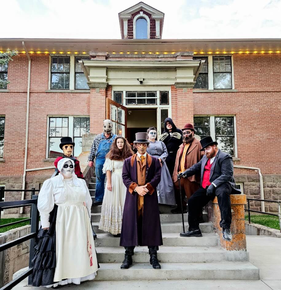 Actors dressed in assorted spooky costumes outside the Haunted Mansions of Albion Haunted House. 