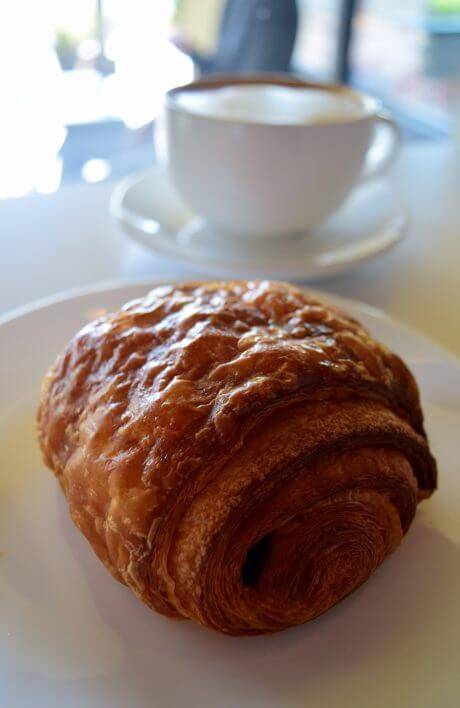 coffee sitting next to a pastry