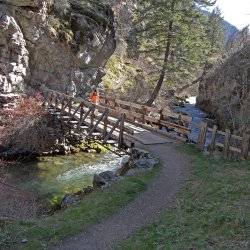 two people walking across a mountain bridge