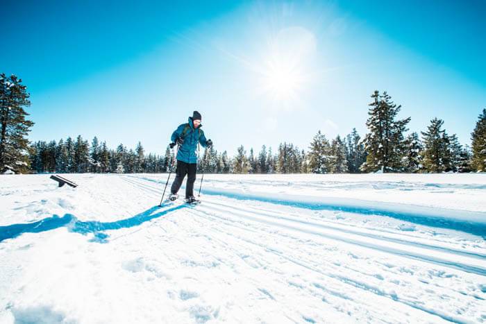 A person in blue snowshoes at Harriman State Park.