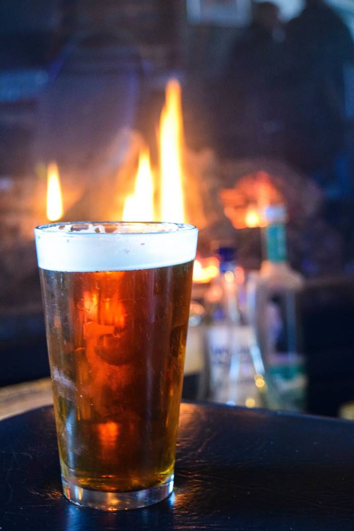 An amber brew silouhetted against a crackling fire at the Capitol Bar in Boise.