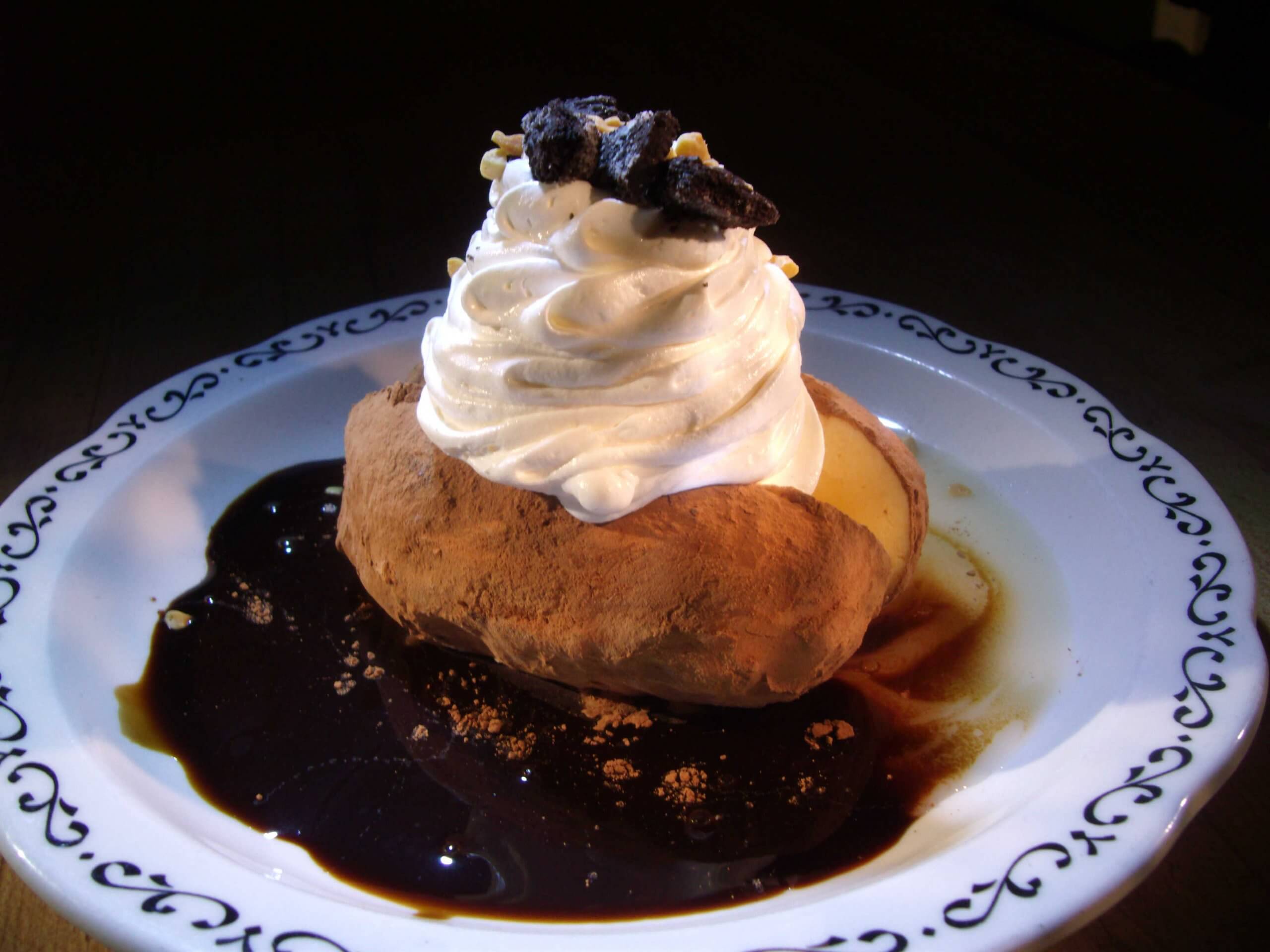 An ice cream potato topped with whipped cream.