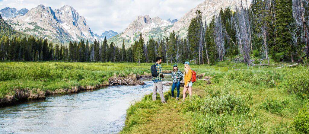 people hiking with mountains in background