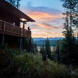 woman sipping coffee from a deck at sunrise