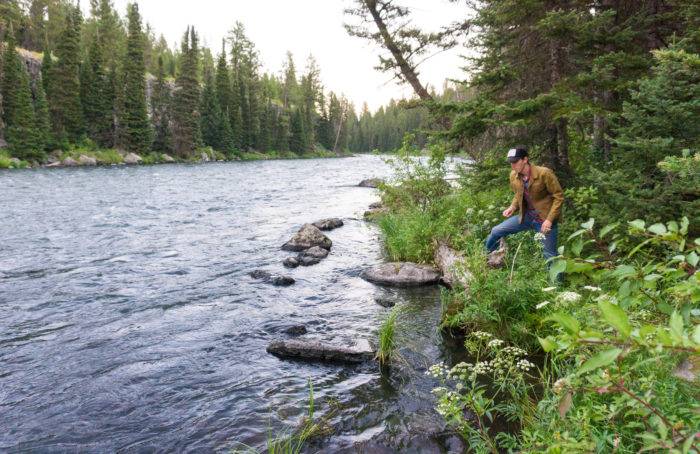 man standing along river