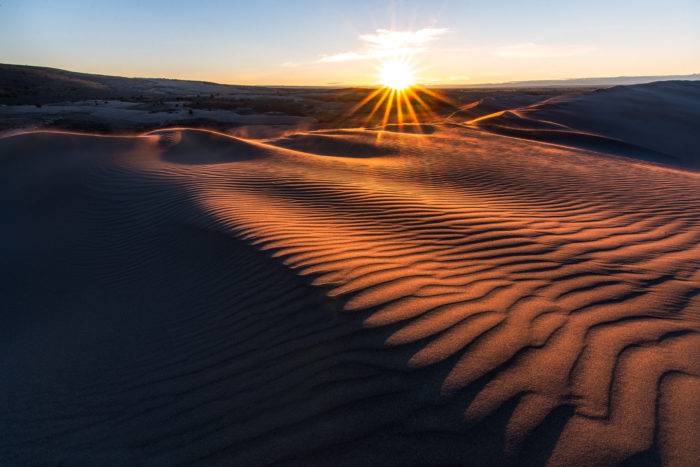 sun rising over sand dune