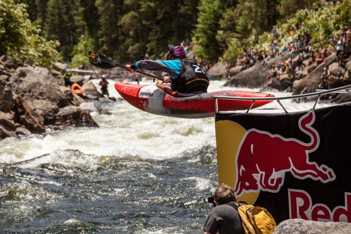 kayaker launching off ramp into river