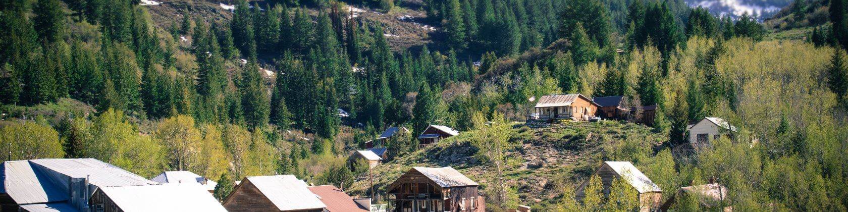 An aerial view of the many wooden historical buildings and forest areas within the mountains in Silver City.