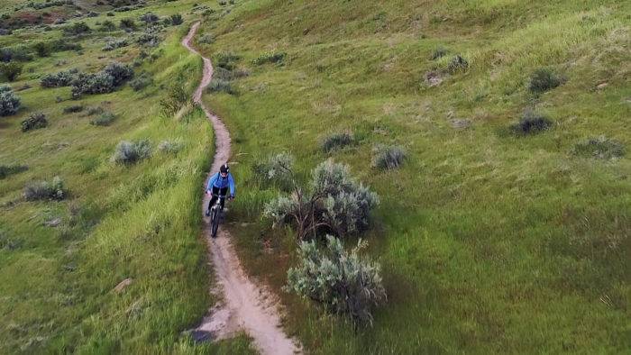 A person in blue rides a bike along a trail at the Ridge to Rivers Trail System in Boise.