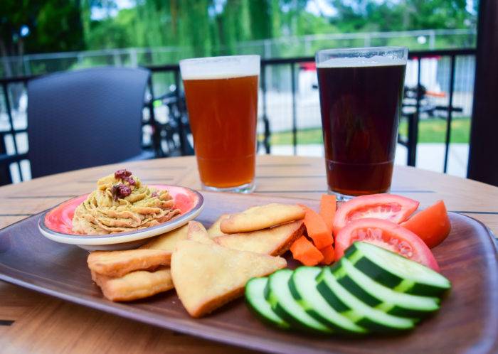 two pint glasses with beer on an outdoor patio.