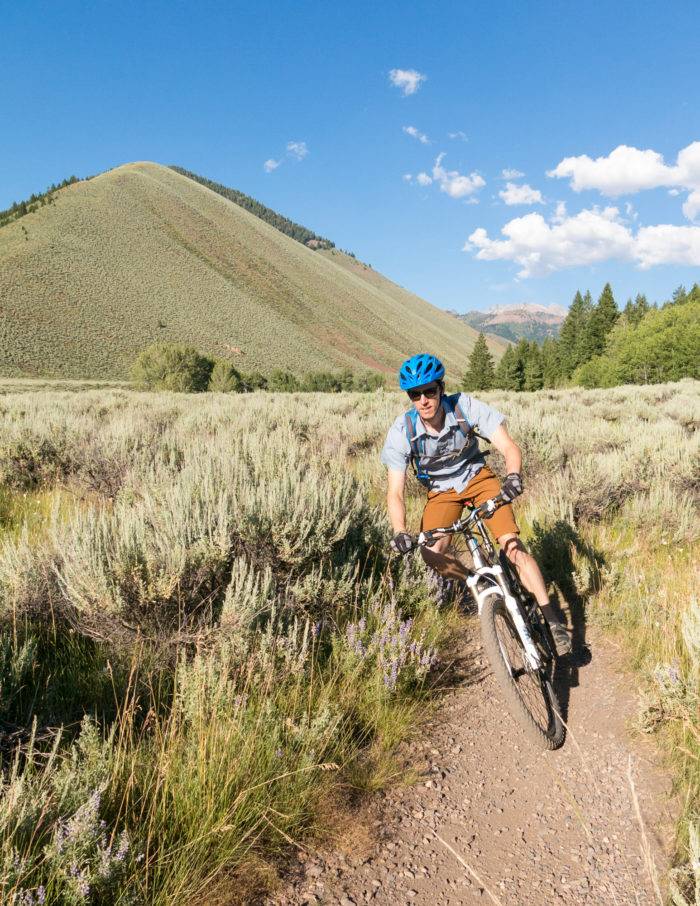 MOUNTAIN BIKER RIDING THROUGH SAGE BRUSH