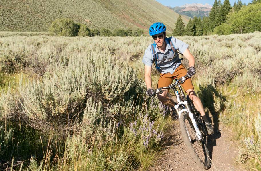 mountain biker riding trail along sagebrush