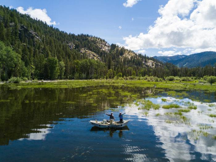 two people on a boat fishing in lake