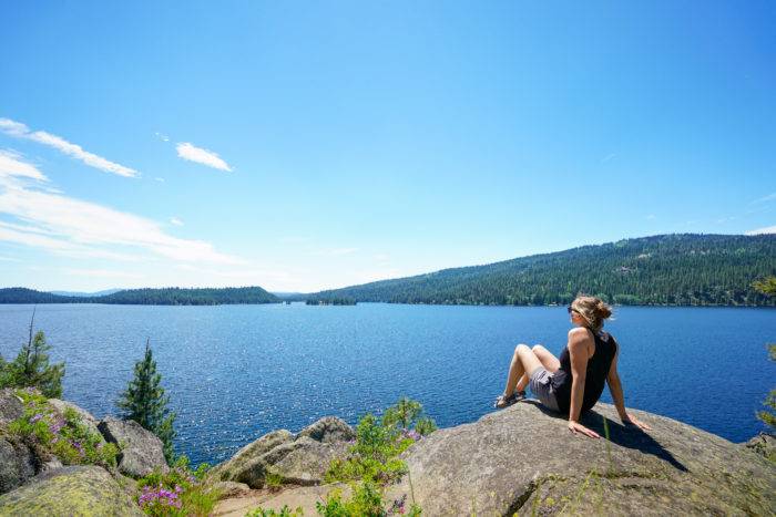 woman sitting on a rock near a lake