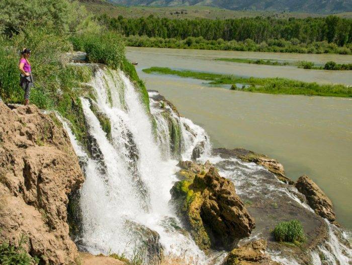 woman standing at top of waterfall