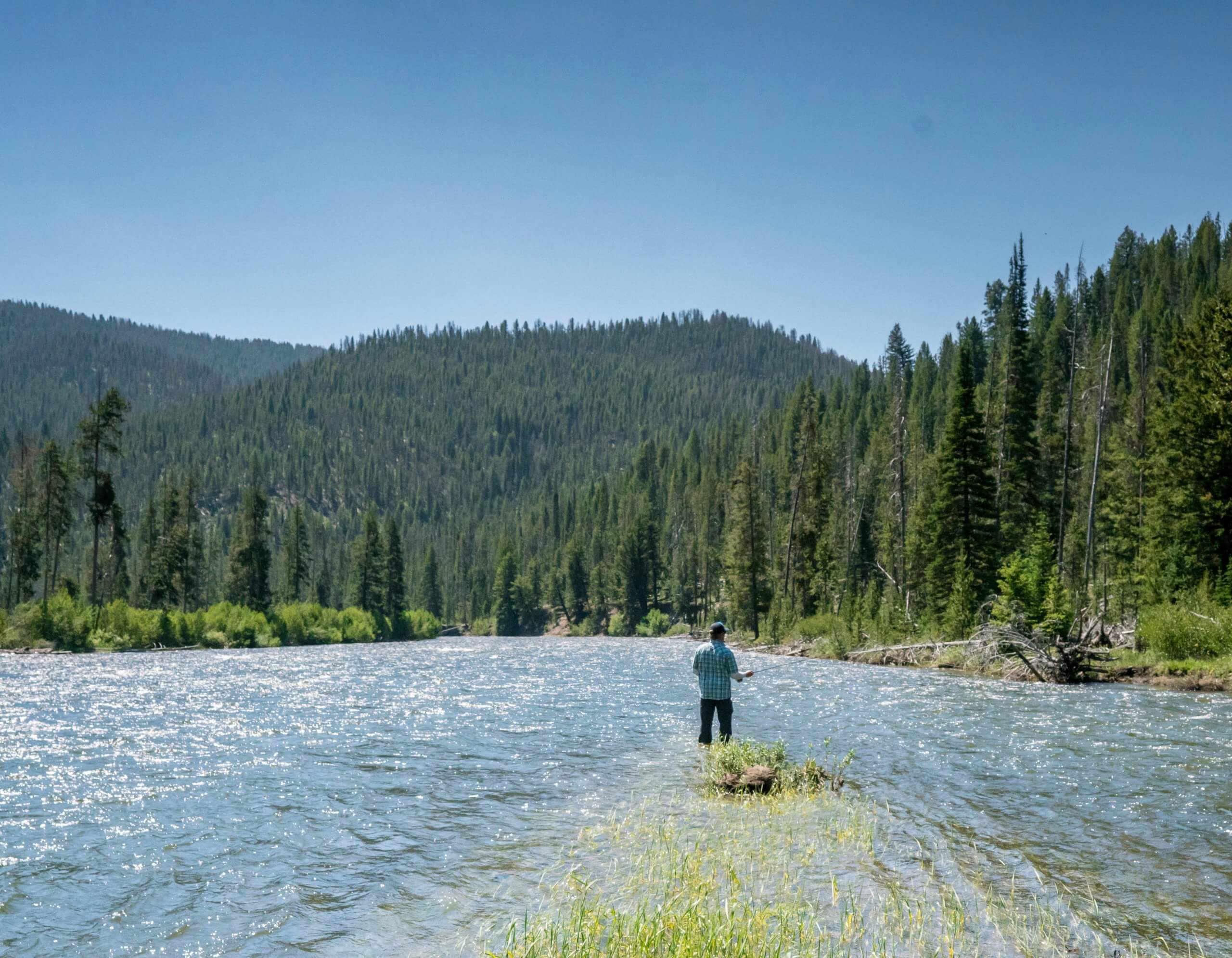 man fly fishing on river