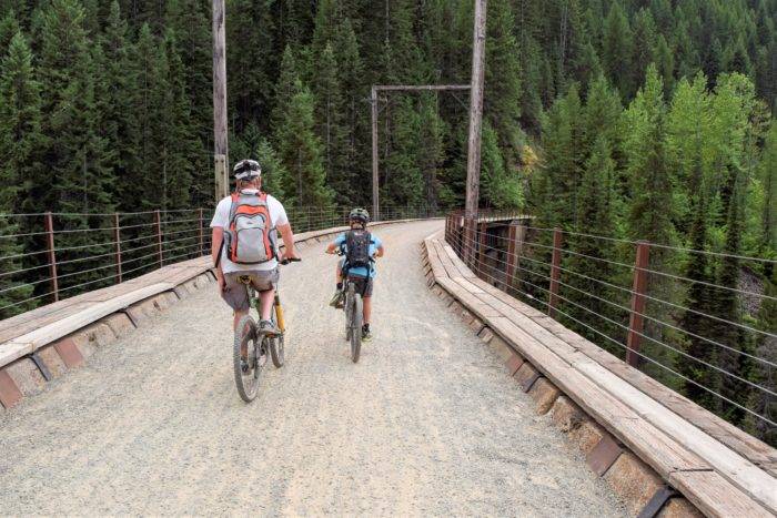 two people on bikes riding on gravel trail