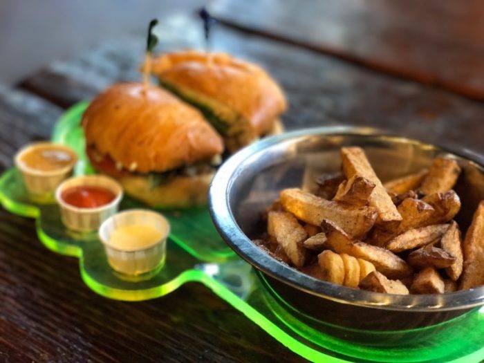 fries and a burger next to dipping sauces