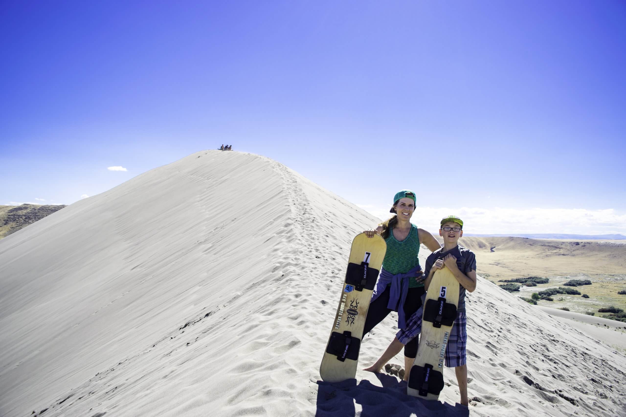 woman and boy standing on top of sanddune