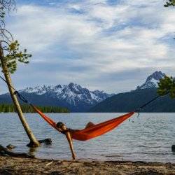 woman in hammock next to a lake