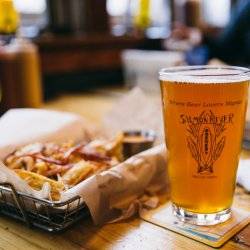 A closeup view of a glass of beer and basket of fries on a table at Salmon River Brewery.