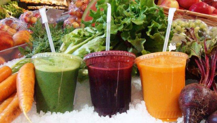 a collection of juices and fresh vegetables