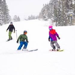 Three people ski and snowboard down a slope at Brundage Mountain Resort.