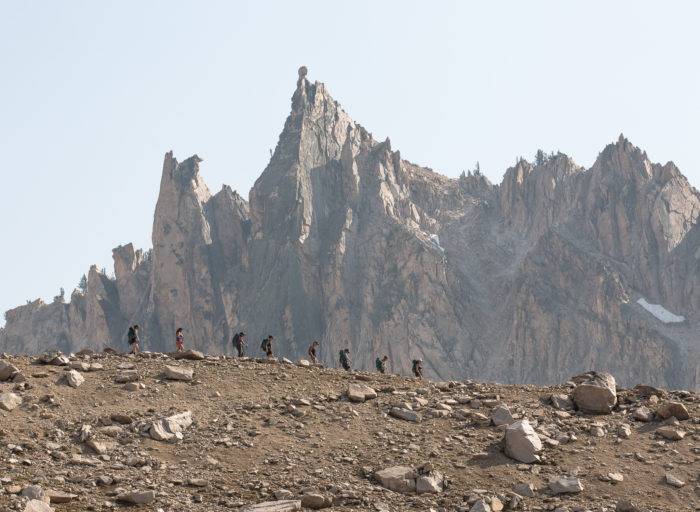 hikers in front of rugged mountains